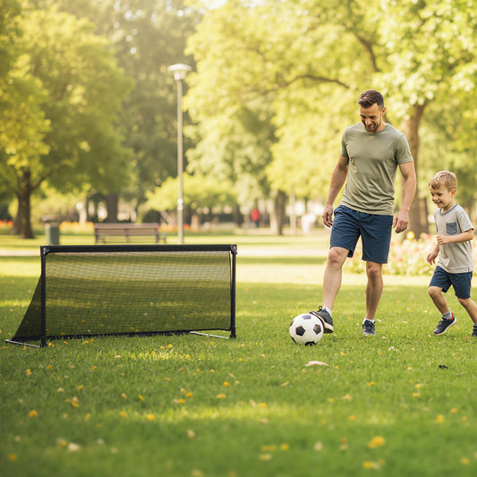 Father and son playing soccer with the goal on a grassy field