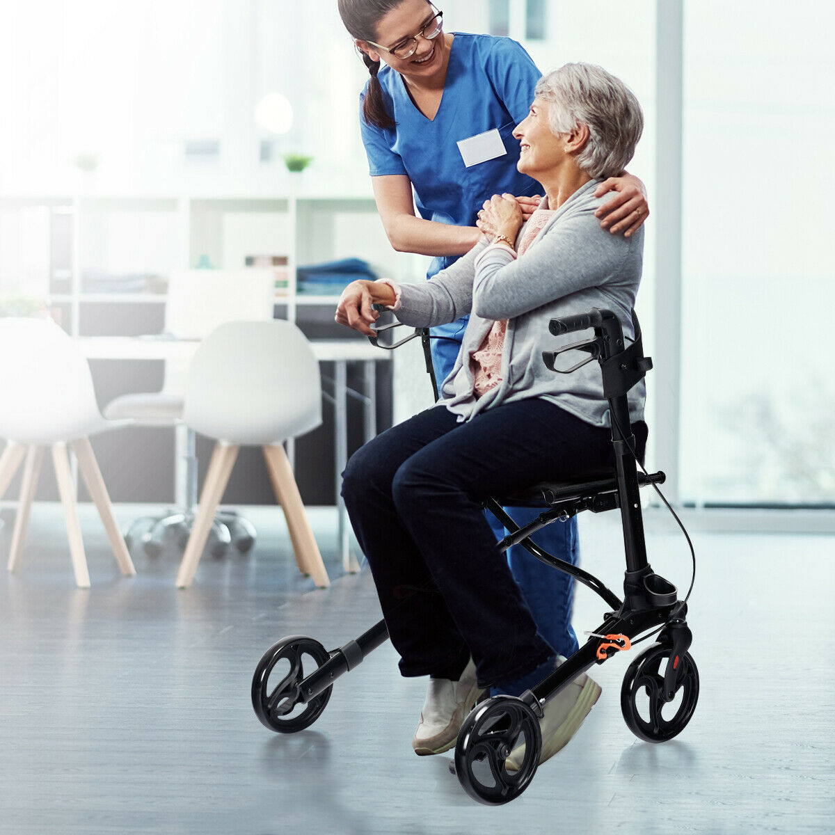 A nurse assisting an elderly woman seated on the black mobility aid indoors