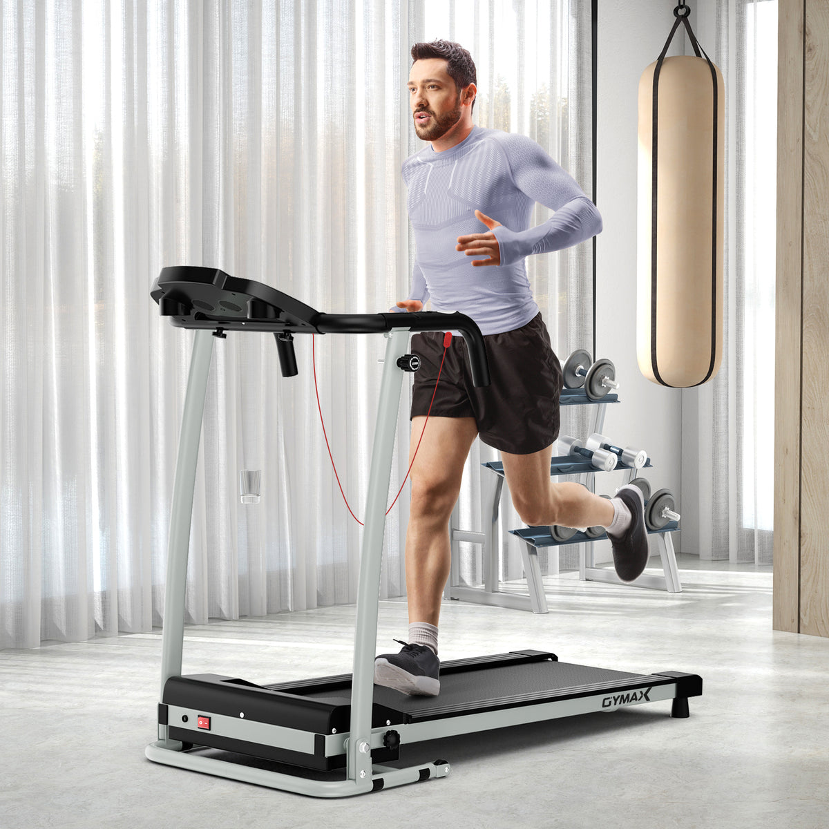 The treadmill in use by a man in a home gym setting with a punching bag in the background