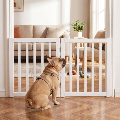 The white wooden pet gate is set up in a doorway, with a French bulldog looking through it into a living room