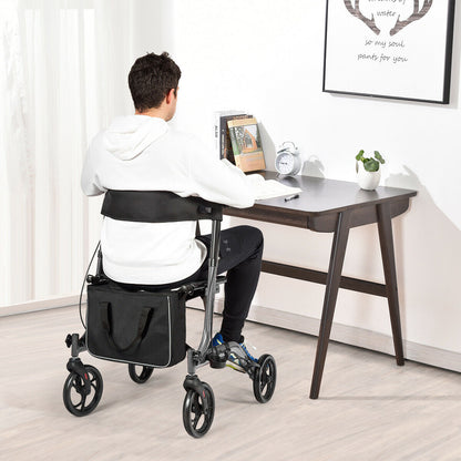 The mobility walker positioned behind a person sitting at a wooden desk in a home office