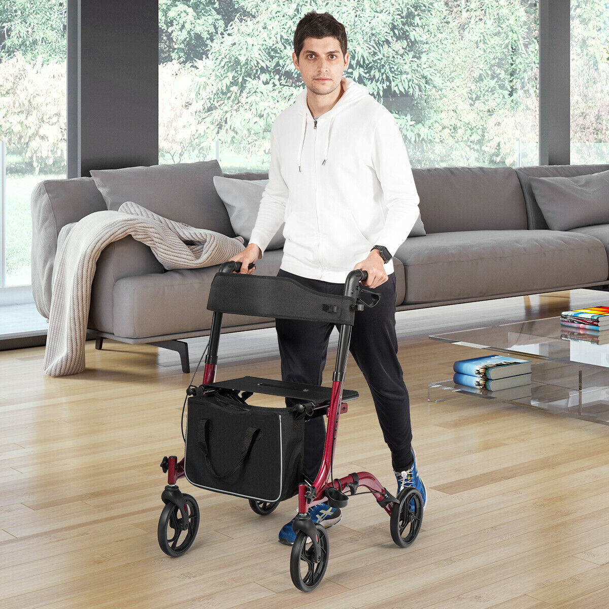 A man stands with the red four-wheeled walker in a modern living room
