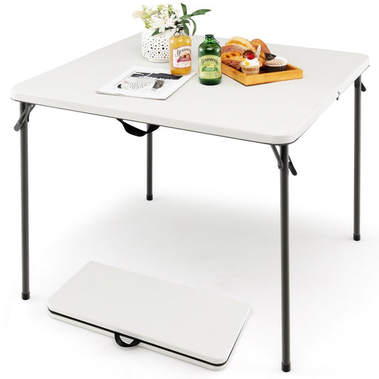 Folding Camping Table with Handle shown set up with food and a folded version on the floor