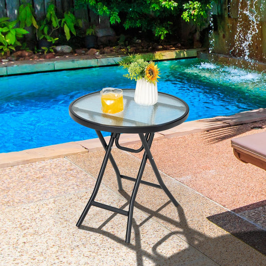 The patio table is placed next to a swimming pool on a paved area