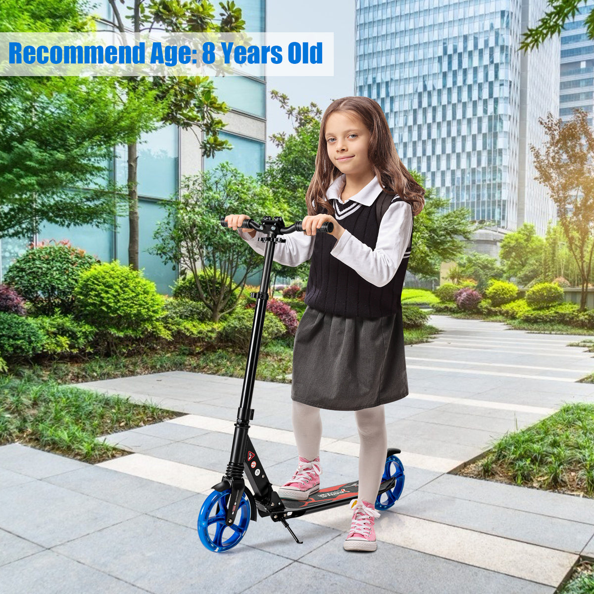 A young girl stands with the black kick scooter on a paved path outdoors