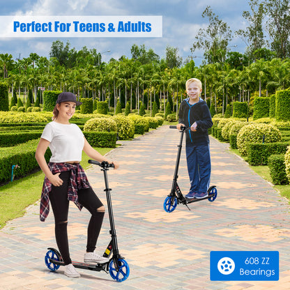 A woman and a boy riding the black kick scooter on a paved path outdoors