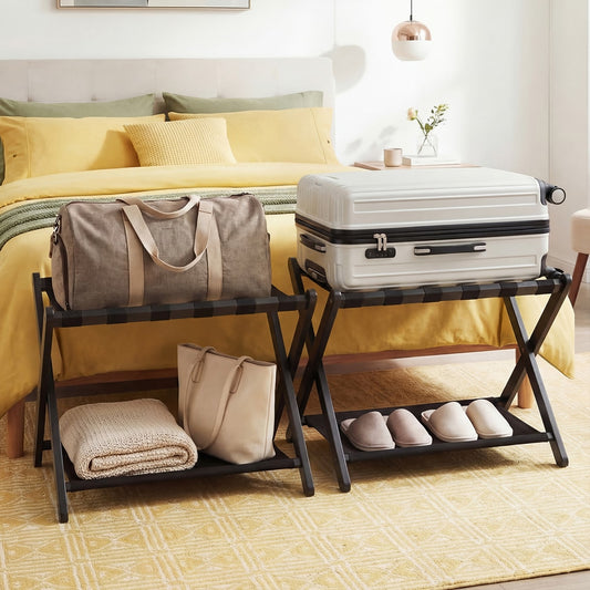 Two black folding luggage racks in a bedroom with suitcases and bags