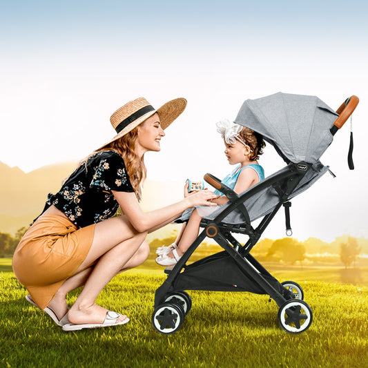Folding Pushchair with Adjustable Backrest and Footrest, the baby stroller being used by a mother and child in a sunny