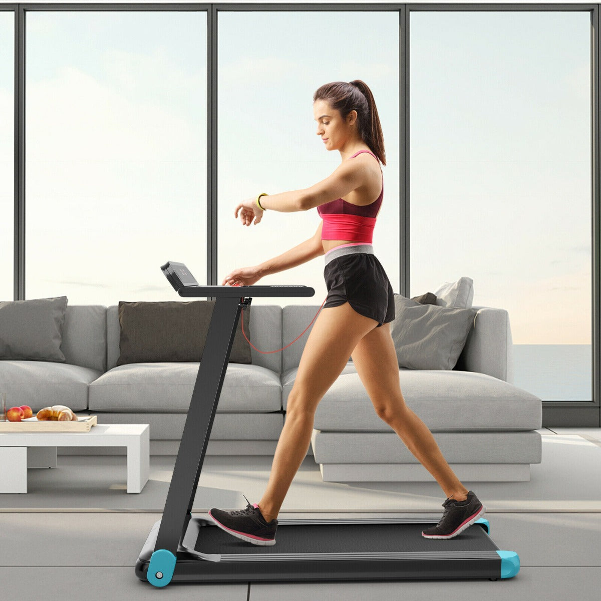 Woman using the blue treadmill while checking her smartwatch