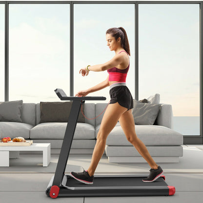A woman using the folding treadmill in a bright living room, checking her smartwatch