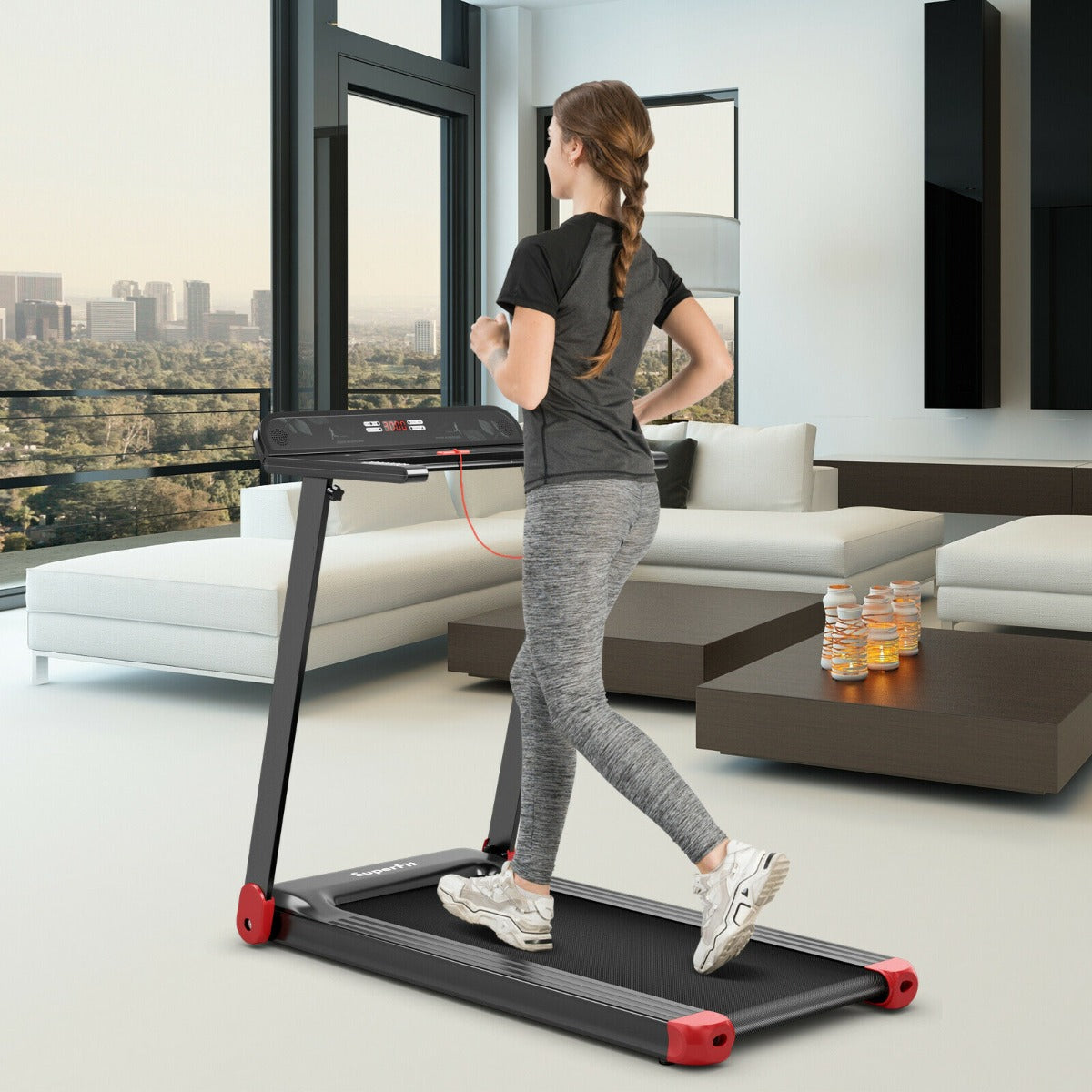 A woman running on the folding treadmill in a modern living room with city views