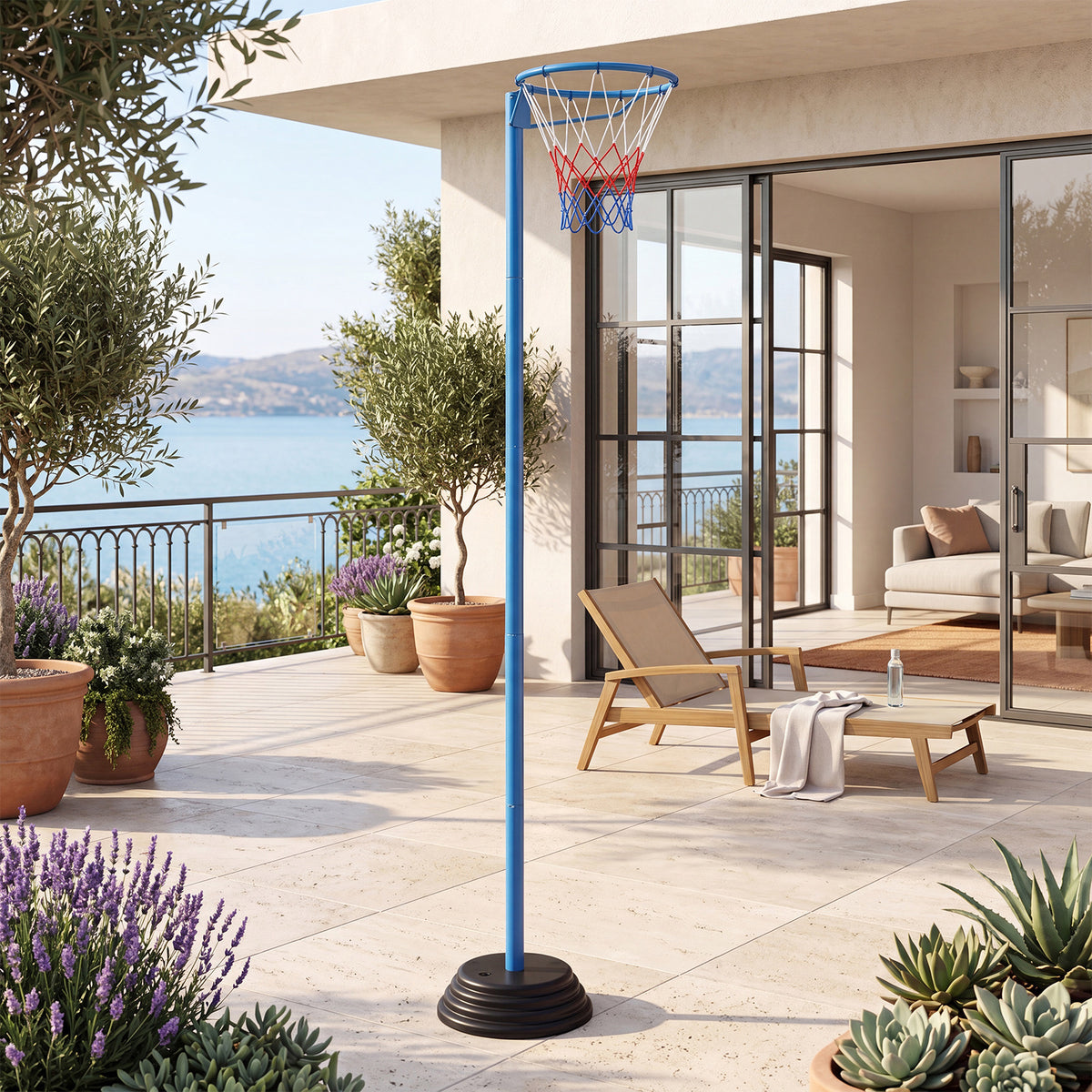The basketball goal is set up on a patio with a sea view