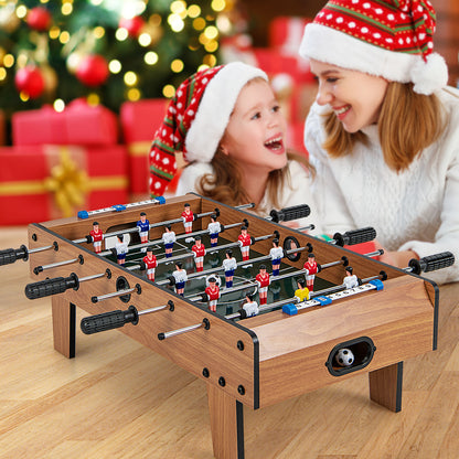 A family enjoys the football table at Christmas, with festive decorations in the background