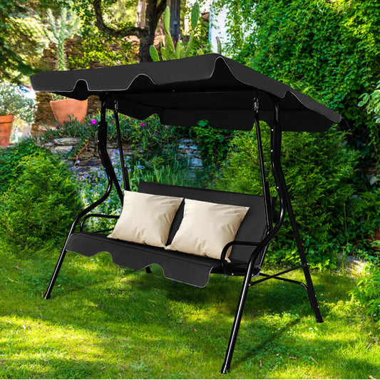 The porch swing placed on a green lawn with two cream cushions on the seat