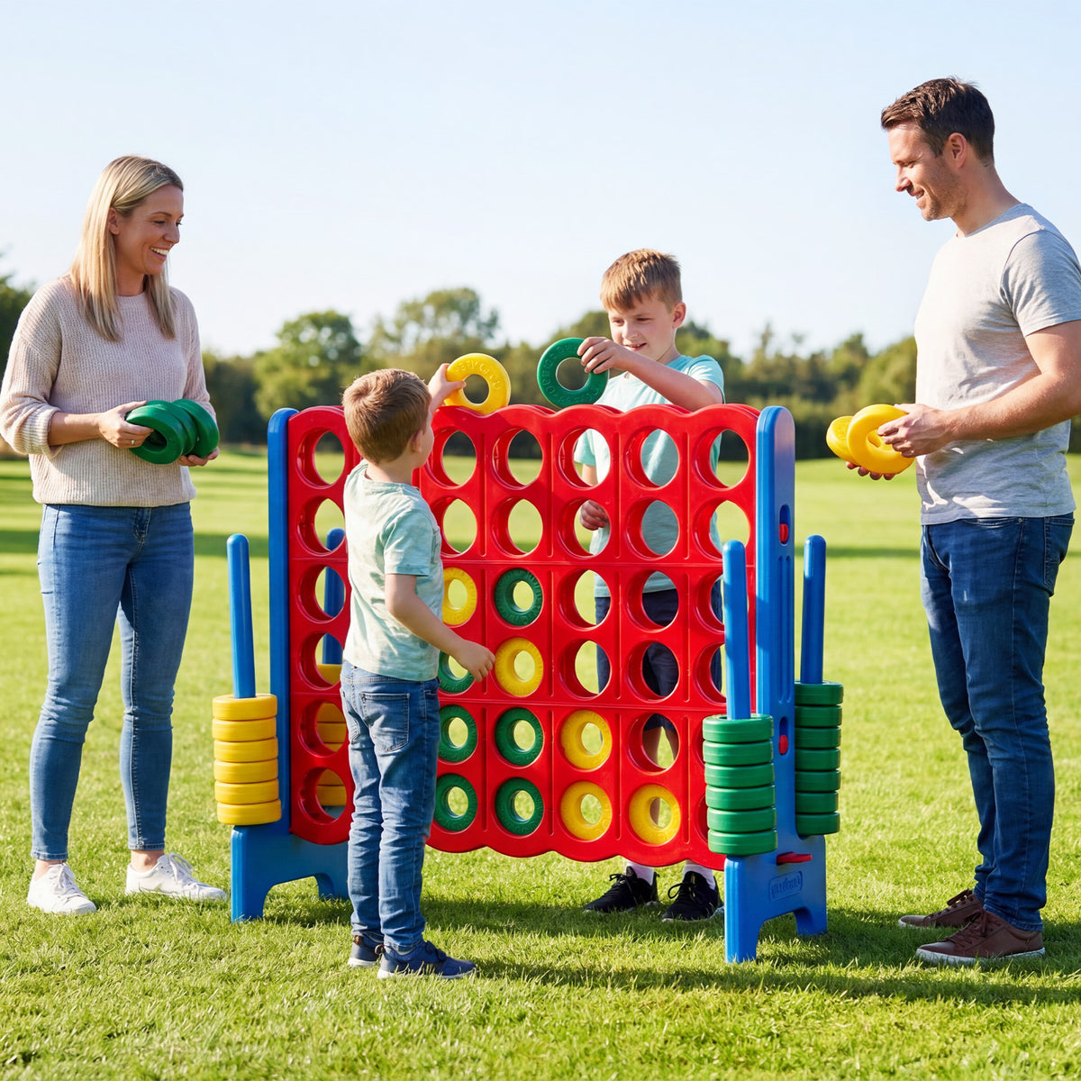 Children and adults playing the giant four-in-a-row game set on grass