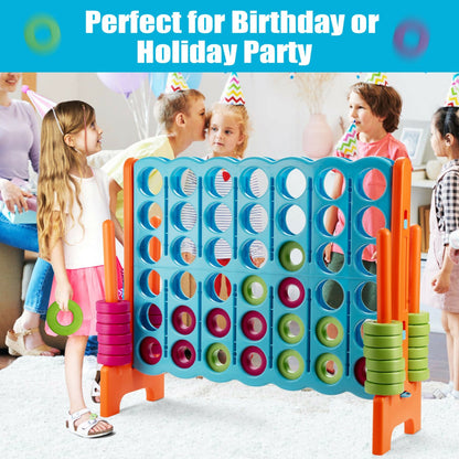 Children playing the giant four in a row lawn game indoors at a party
