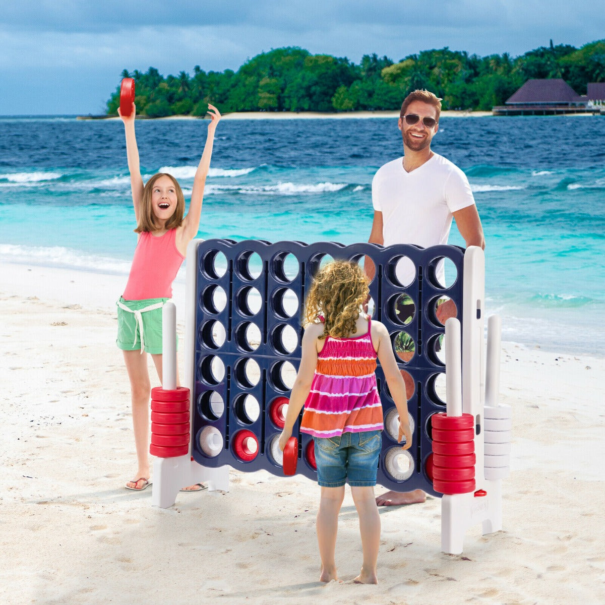 The lawn game being played by a family on a sunny beach with blue ocean waves in the background