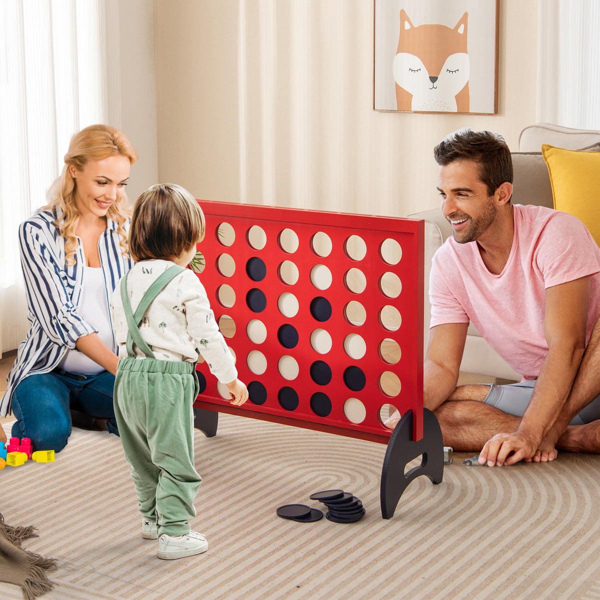 A family plays the giant four-in-a-row game indoors