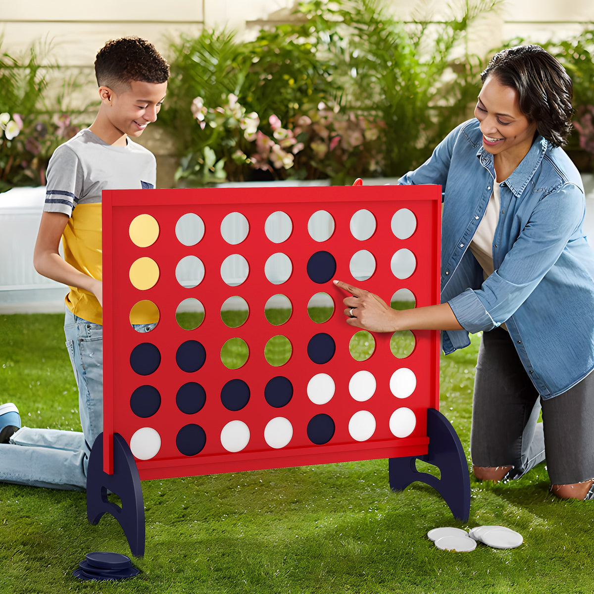 A family plays the giant four-in-a-row game on the lawn