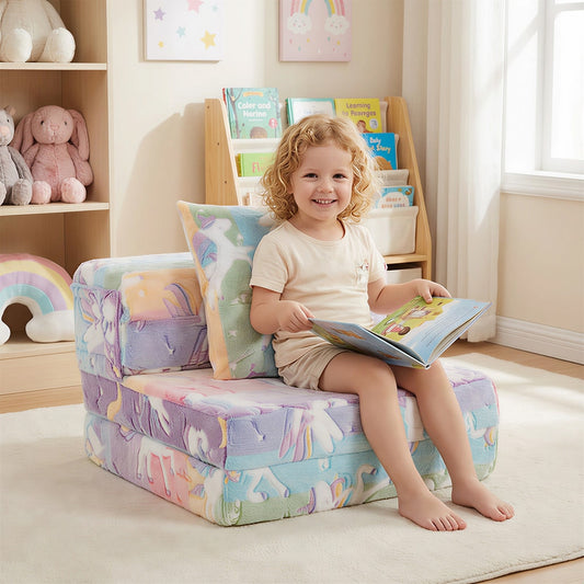 A young child sits on the colourful kids sofa in a bright room