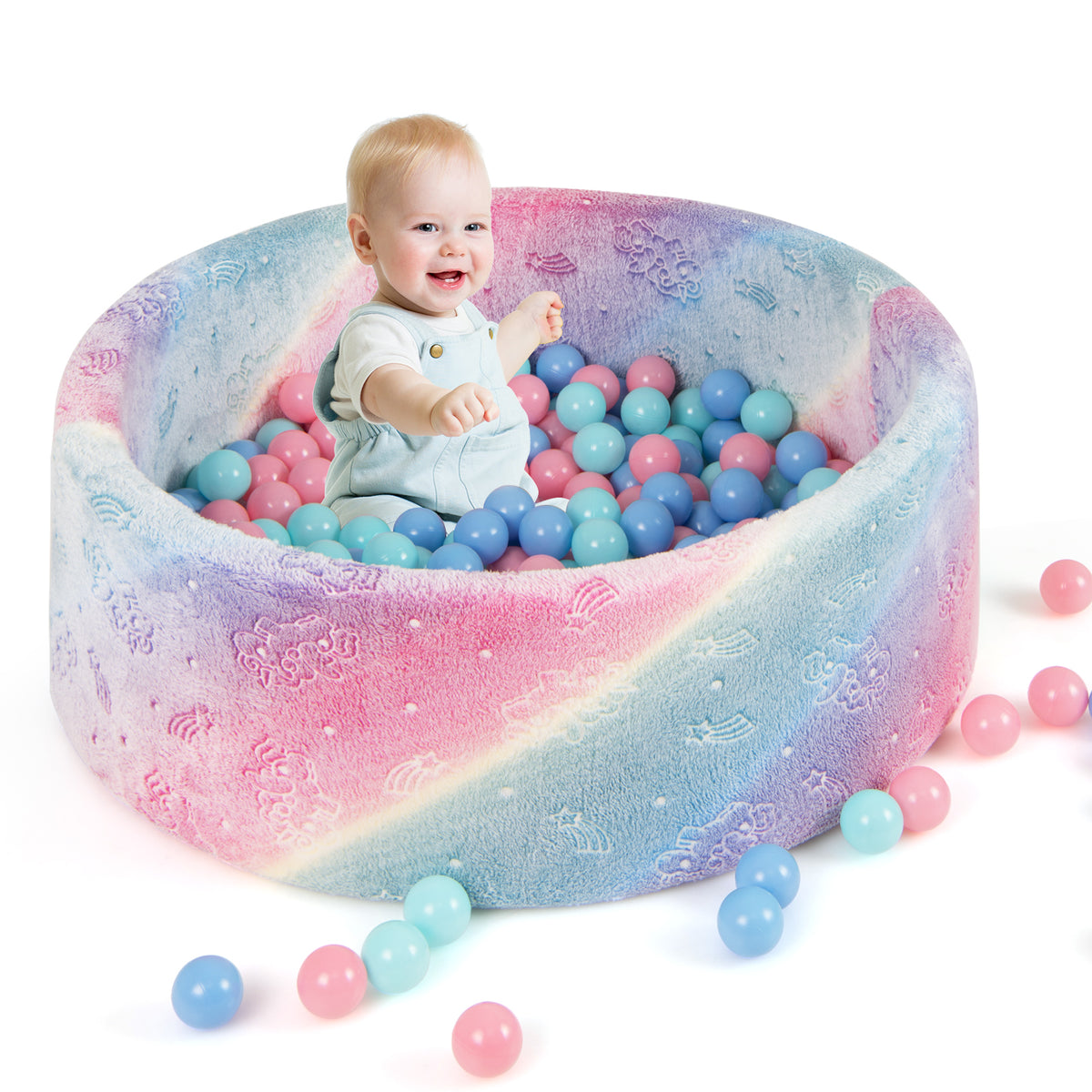 A smiling baby sits in the soft round ball pool filled with pastel coloured balls