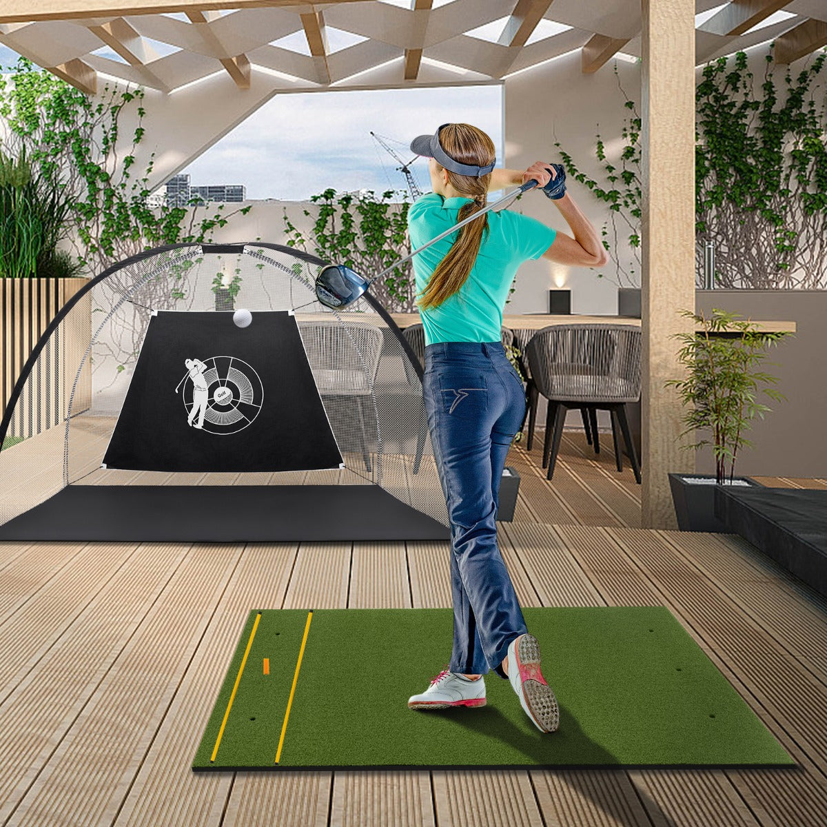 Woman practicing golf swings on a golf hitting mat on a balcony with a golf net
