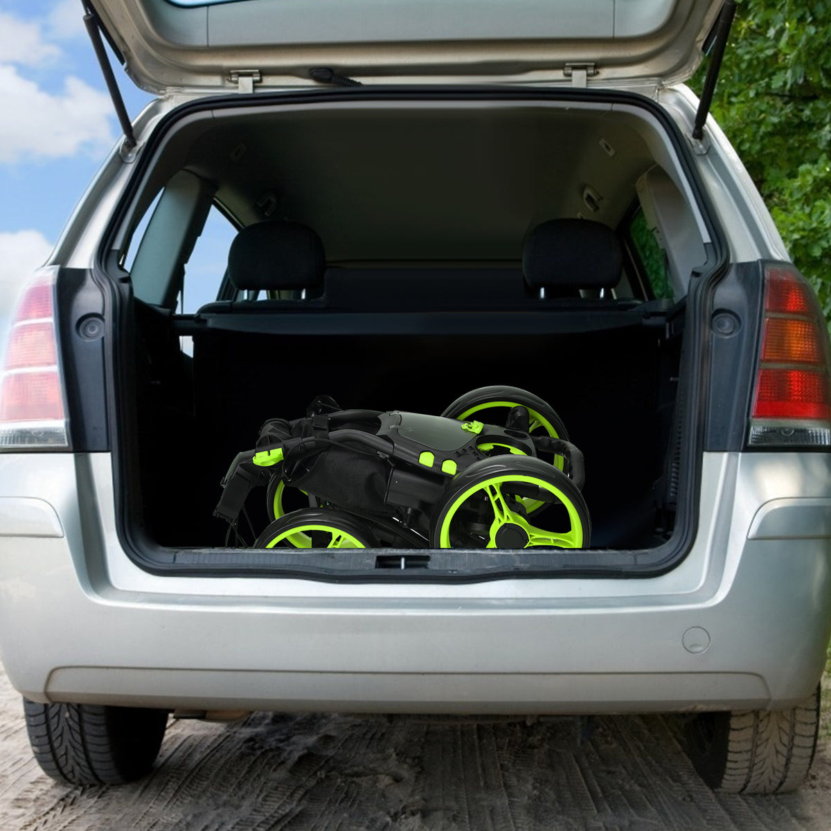 The folded golf trolley sitting inside the open boot of a silver car