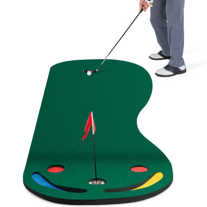 The putting green mat with a golfer using a club to hit a ball towards the hole