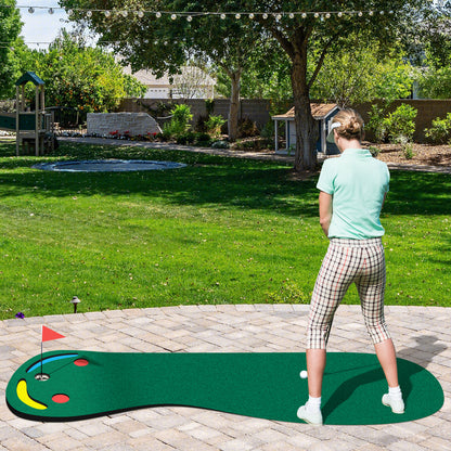 The putting green laid out on a stone patio in a sunny garden with a person playing