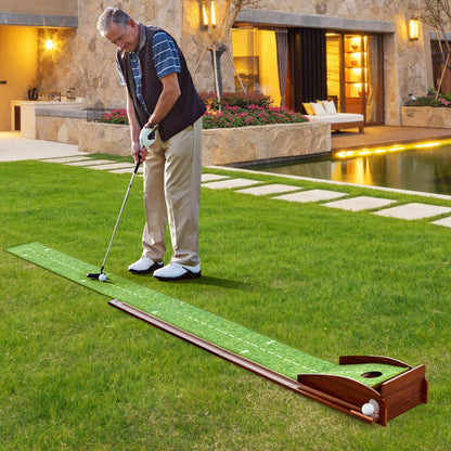 The golf putting mat training aid set up on a lawn with a man practising his putting