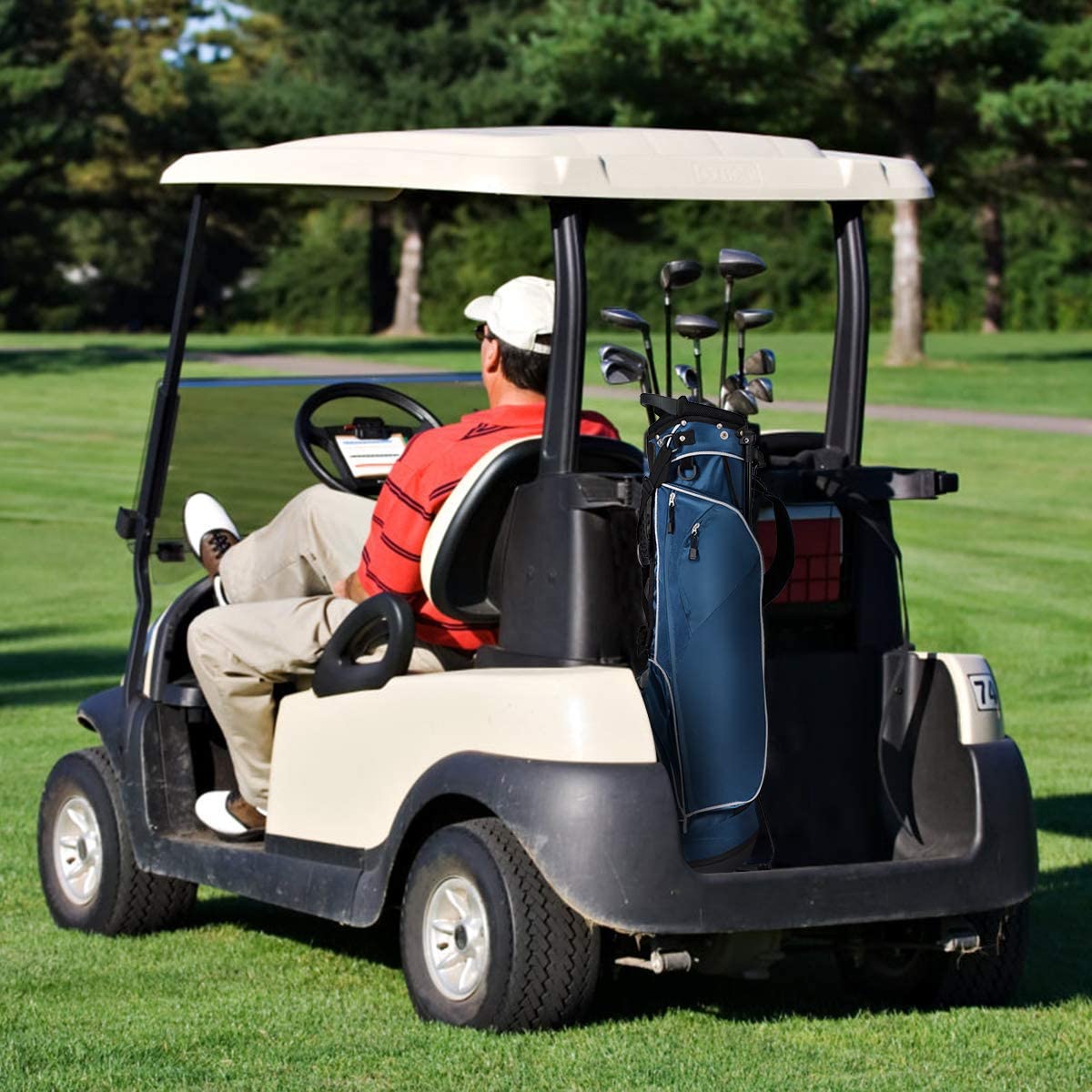 The navy golf stand bag in a golf cart with a man driving