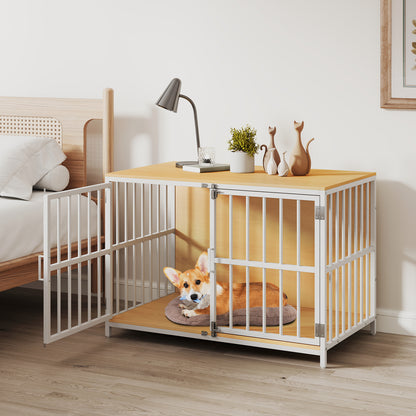 A small dog sits inside the dog kennel furniture with one door open, next to a bed