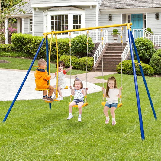 Children enjoying the blue and yellow swing set in a grassy garden with a house behind