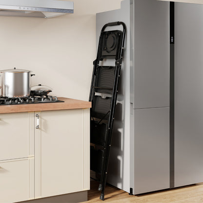 The black folding ladder stored in a narrow gap beside a large silver fridge