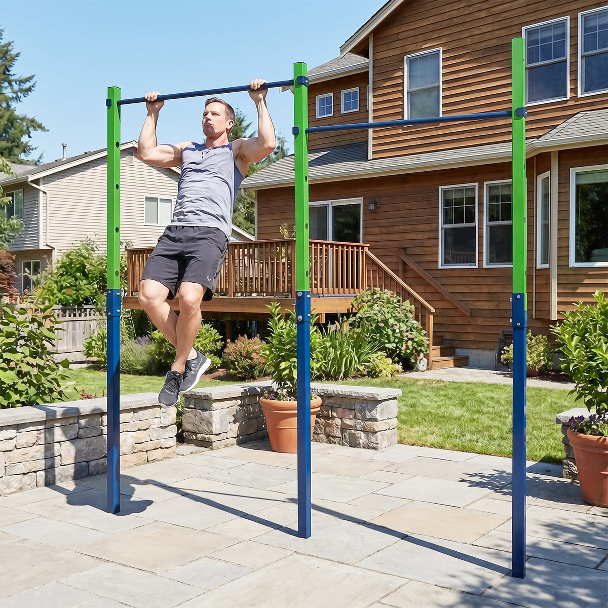 Man doing pull ups on the blue and green pull up bar station outdoors