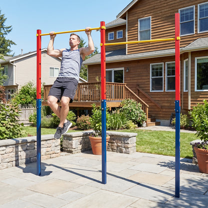 A man doing pull ups on the red and blue pull up bar station in a garden