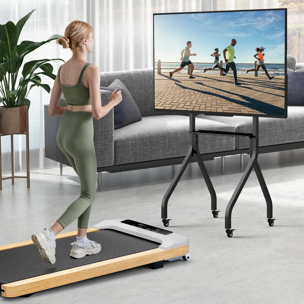Woman walking on treadmill next to the floor TV stand