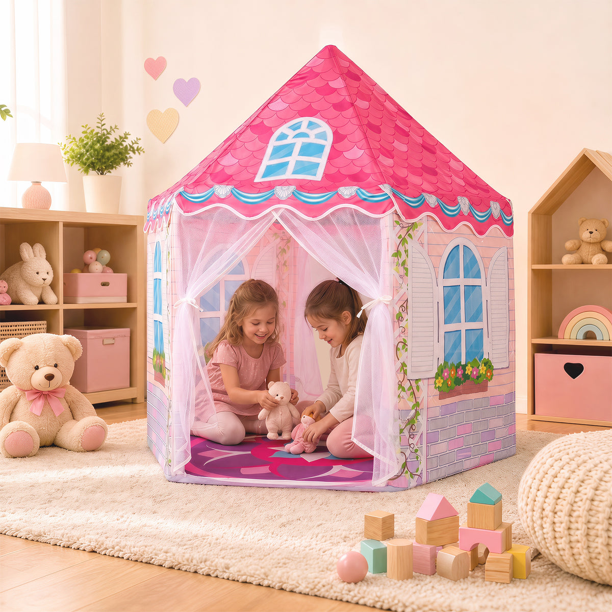 Two girls playing inside the pink hexagonal play tent in a room