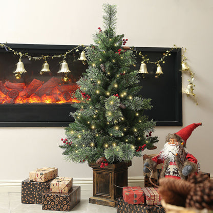 The pre lit Christmas tree placed in a living room next to a fireplace with gifts and decorations