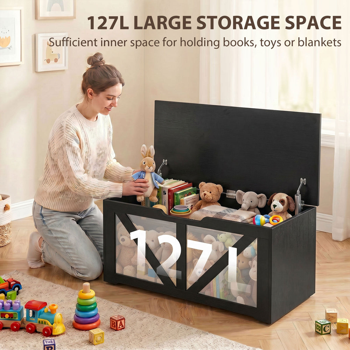Woman placing toys into a large storage box with 127L capacity shown