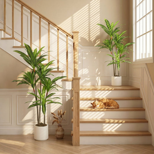 The artificial plant in a white pot placed on a wooden staircase landing next to a cat