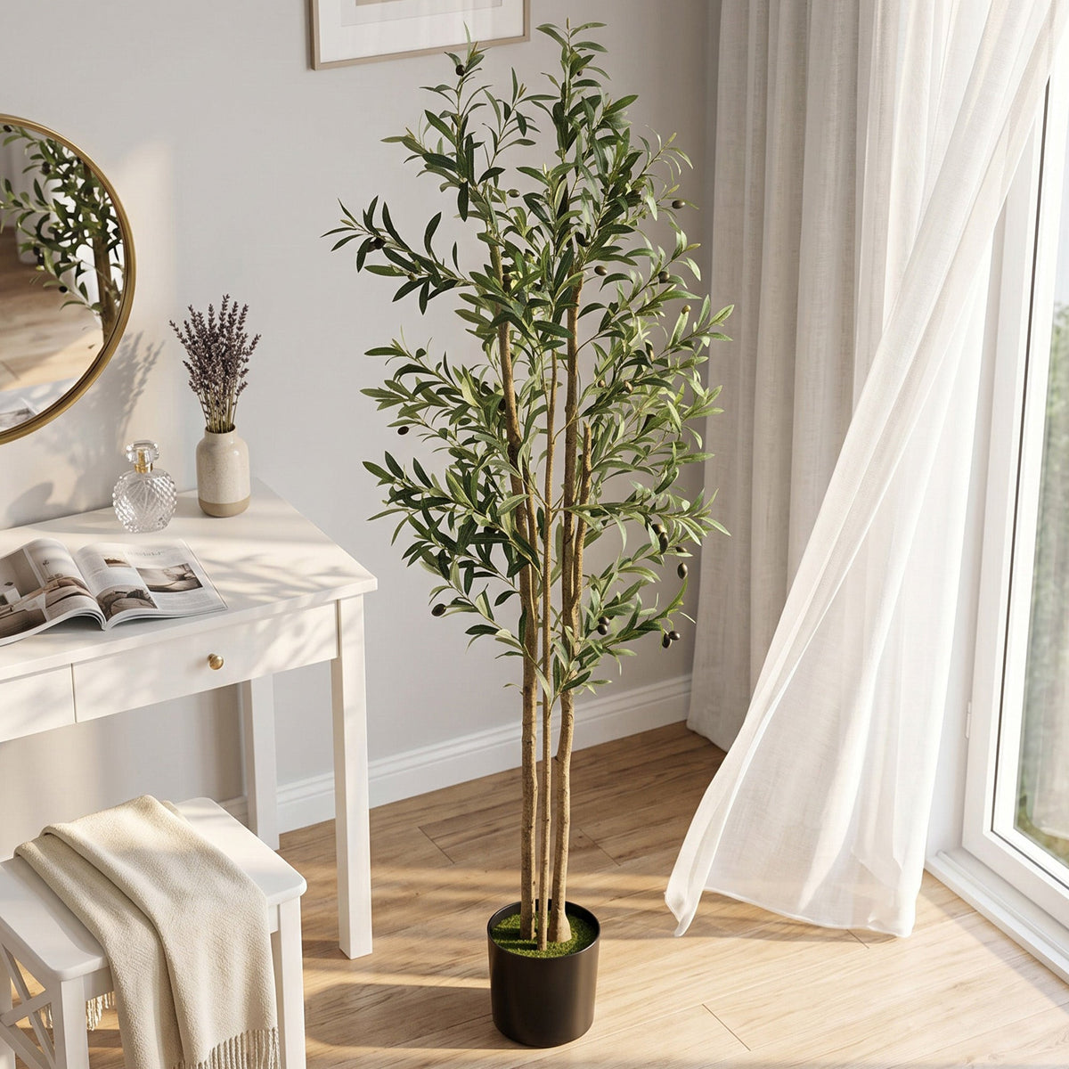 The artificial olive tree placed in a bright living room next to a white desk and window
