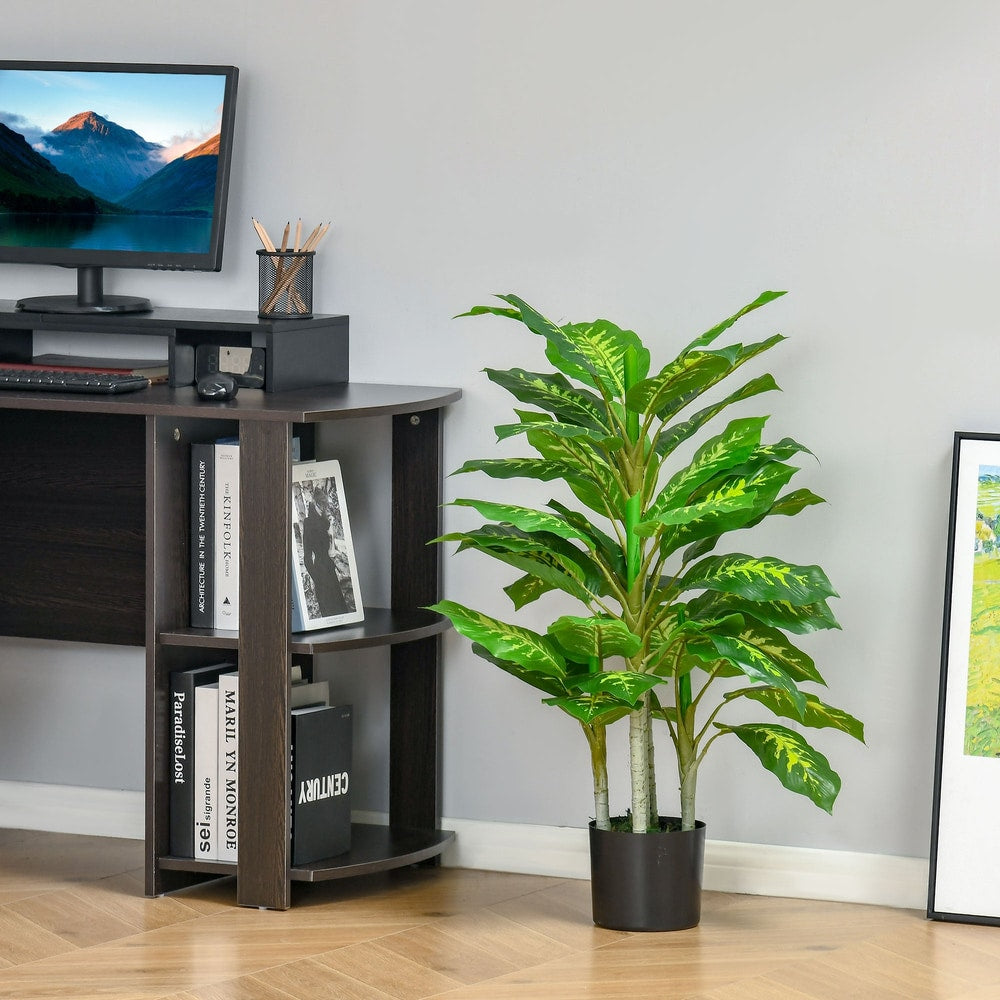 The artificial evergreen tree next to a desk with a computer and shelves