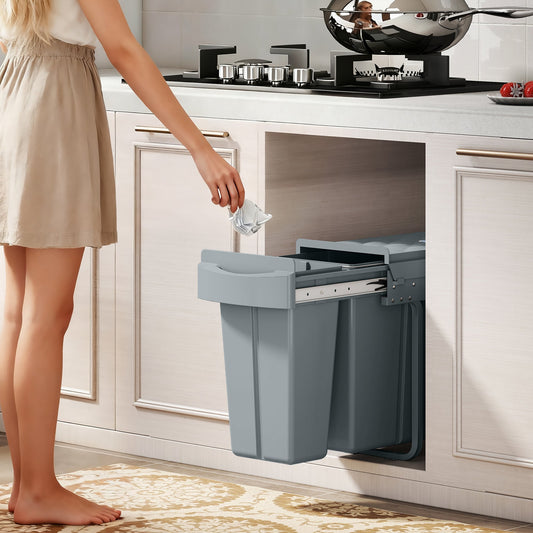 The kitchen trash bin pulled out from under a counter while a person throws away rubbish