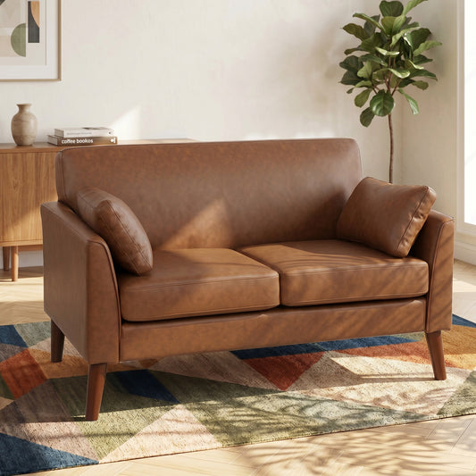 The brown two seater sofa placed in a bright living room on a patterned rug next to a house plant