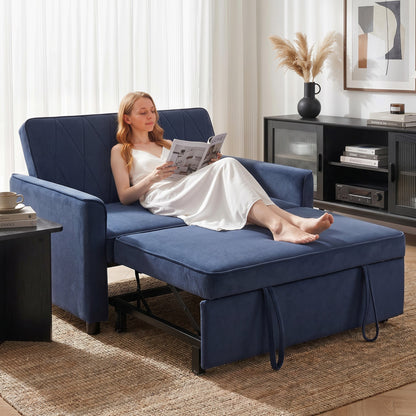 The dark blue sleeper sofa in a living room with a woman sitting on it reading a book