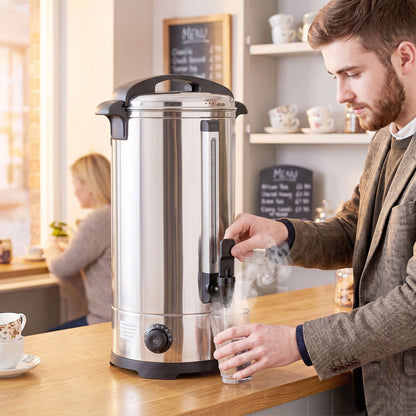 A man pouring hot water from the catering urn into a glass in a cafe setting