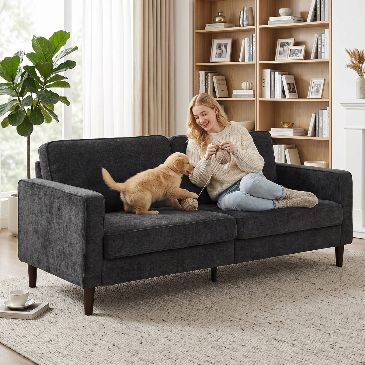 A woman and a puppy on the dark grey upholstered sofa in a cosy room