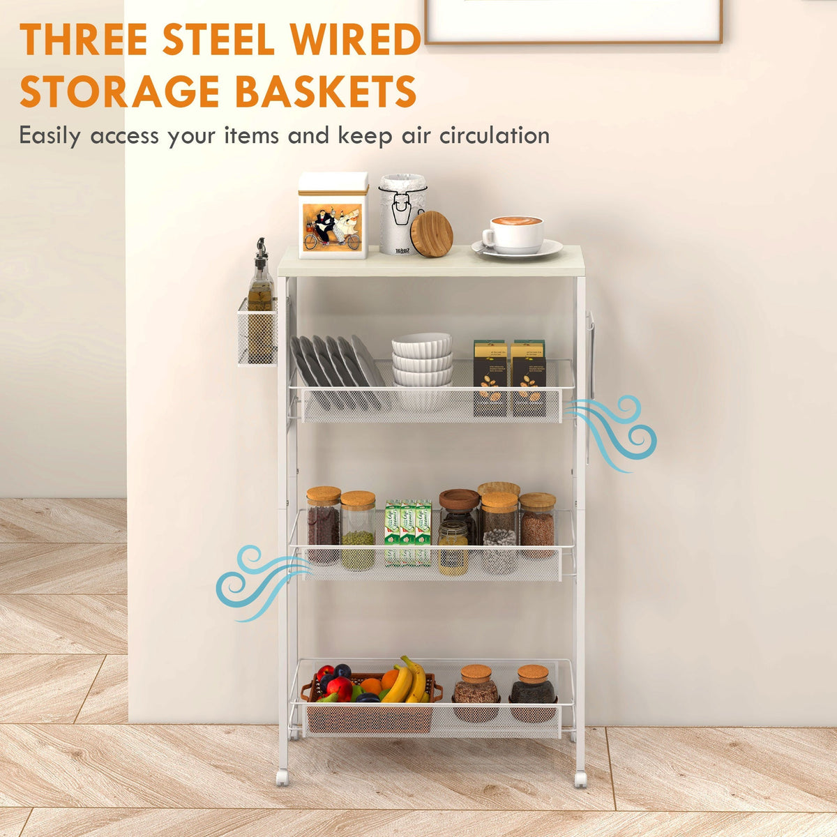 White kitchen trolley with three wire baskets, holding plates, jars and fruit