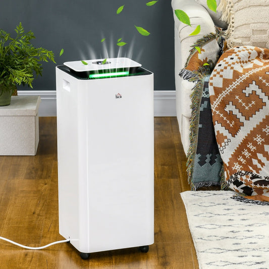 The portable dehumidifier and air purifier in a living room setting next to a sofa and a plant